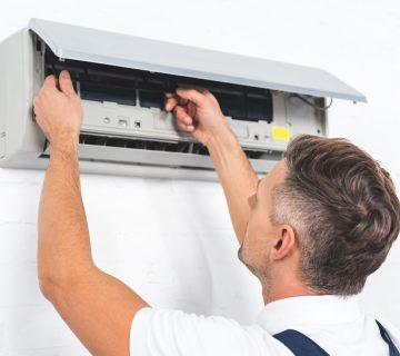 repairman fixing air conditioner on wall